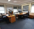Office with two desks, chairs, computers, printer, and storage boxes.