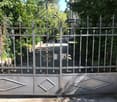 Metal gate with decorative patterns, two sections, located at the entrance of a property