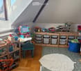 {"type": "Furnished Room", "objects": ["table", "chair", "shelf", "storage bins", "toy car", "toy airplane", "toy truck", "toy screen", "ball", "toy crane", "toy toolbox", "toy camera", "toy camera tripod", "toy camera stand", "toy camera case", "toy came