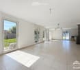 Empty room with tiled floor, white walls, large windows, and a fireplace in the corner.