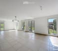 Empty room with white walls, tiled floor, and multiple large glass doors leading to an outdoor area.