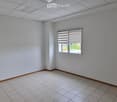 Empty room with white walls, tiled floor, and a single window with blinds.