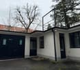 White house with garage, terrace on the top, black railings, black windows