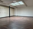 Open room, wooden floor, white ceiling, glass roof, built-in white cabinets, light fixture