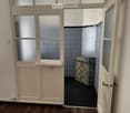 tiled wall, wooden floor, open door, light switch, tiled sink