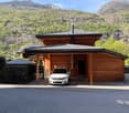 wooden house, covered parking, mountains in the background