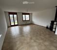 Empty room with tiled floor, large window, and sliding glass door leading outside.