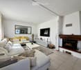 Modern living room with a large sectional sofa, coffee table, fireplace, TV, and decorative items.