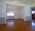 Empty room with wooden flooring, white walls, and a window with blinds. No furniture or equipment present.