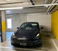 {"visible_features": ["Garage"], "type": "Garage", "objects": [], "description": "Underground parking space with a single car parked in bay number 105, concrete walls and ceiling, fluorescent lighting, and a small window on the left side.", "localized_des