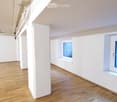 Empty room with white walls, wooden floor, and two windows. No furniture or equipment present.
