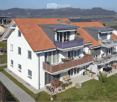 Modern two-story house with red-tiled roof, white exterior, multiple balconies, outdoor seating areas, and a scenic countryside view.