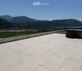 Roof terrace with tiled flooring, metal safety railing, and scenic mountain and lake view.