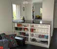kitchen and living area, open plan, bar counter, leather couch, bookshelf, glasses and books, dining table
