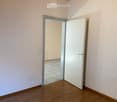empty room, white walls, wooden floor, open door, tiled floor in the next room