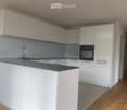 Modern kitchen with white cabinets, a central island, and a stainless steel sink and faucet.