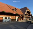The exterior of a house made of red tiles, wooden beams, wooden doors, glass windows, and stairs.