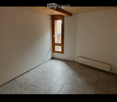 Empty room with tiled floor, white walls, wooden door with glass panel, and radiator on one wall.