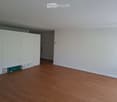 Empty room with light-colored walls, wooden flooring, and a white closet. No furniture or personal items are present.