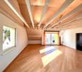 {"visible_features": ["View"],    "type": "Room",    "description": "Spacious attic room, wooden flooring, wooden ceiling beams, large window with curtain, door leading to balcony with railing",    "localized_descriptions":        {        "EN": "Spa