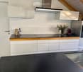 Modern kitchen with white cabinets, black countertop, stainless steel appliances, and decorative items on the counter.