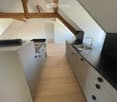 Kitchen. Modern kitchen with white cabinets, black countertops, and a stainless steel sink. Wooden flooring and exposed wooden beams on the ceiling.