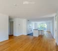 Empty room with wooden flooring, white walls, and a doorway leading to another space. No furniture or equipment is present.
