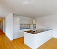 Modern kitchen with white cabinets, a central island, and a stainless steel sink.