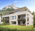 modern two-story house, three levels, large glass windows, multiple balconies, large grassy area in front, mountain view