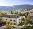 Aerial view of a multi-story residential building with a view of the mountains