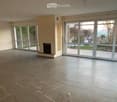 Empty room with large glass sliding doors, fireplace, and tiled floor.