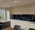 Modern kitchen with white cabinets, black countertops, and a central island with bar stools. Features a built-in oven, sink, and ample natural light from large windows.