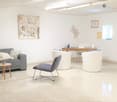 Modern living room with a grey sofa, wooden coffee table, white floor lamp, and decorative artwork on the walls.