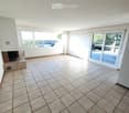 Empty room with tiled floor, fireplace, large windows, and sliding glass door leading to outdoor area.