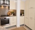 Modern kitchen with white cabinets, stainless steel appliances, granite countertops, and decorative items including potted plants and a bowl of lemons.
