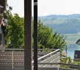 Balcony overlooking a scenic countryside with trees and distant hills.