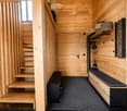 Wooden hallway with built-in bench, shelves, and staircase leading upwards.