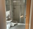 white tiled floor, toilet, sink, shower