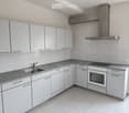 Modern kitchen with white cabinets, granite countertops, stainless steel sink, oven, and stove.
