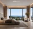 Modern bedroom with large windows, a large bed, nightstand, lamp, ottoman, armchair, side table, and a view of the landscape.