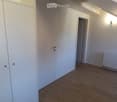 Empty room with wooden flooring, white walls, a radiator, and a closet. No furniture or equipment present.