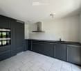 Modern kitchen with dark grey cabinets, stainless steel appliances, marble tile flooring, and a central island with a sink and faucet.