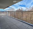 Balcony with tiled floor, metal railing, and scenic view of trees and mountains.