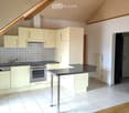 Modern kitchen with light-colored cabinets, stainless steel appliances, a central island, and tiled flooring.