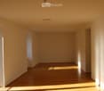 Empty room, wooden floor, white walls, ceiling light, glass door, balcony