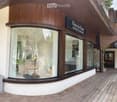 Storefront with large glass windows, wooden facade, and signage reading "Fleur de Pierre" and "Boutique & Accessoires".