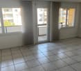 Empty room with tiled floor, large windows, and sliding glass door leading to a balcony.
