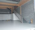 empty room, concrete floor, wooden beams, staircase, gray walls
