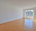 Large room, parquet floor, white walls, sliding doors to balcony, radiator, window to street