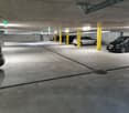 empty parking garage with cars parked in parking spaces and yellow pillars